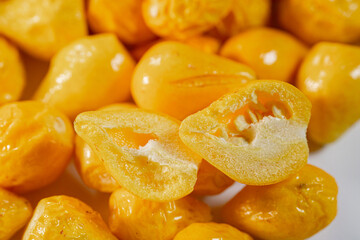 A detailed close-up of freeze-dried Argentine chili peppers, showcasing their vibrant yellow color, glossy texture, and seeds. Perfect for culinary or spice applications.