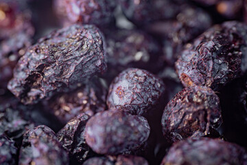 A detailed close-up of freeze-dried honeysuckle berries, showcasing their deep purple hue, wrinkled texture, and natural appeal. Perfect for culinary or snack applications.