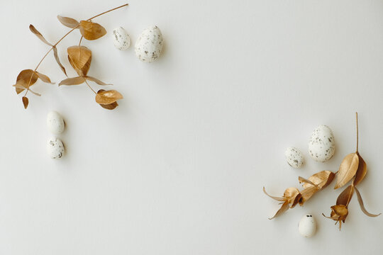 Close-up top view of golden Easter eggs on white background, Happy Easter minimal concept