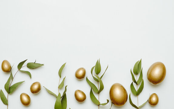 Close-up top view of golden Easter eggs on white background, Happy Easter minimal concept