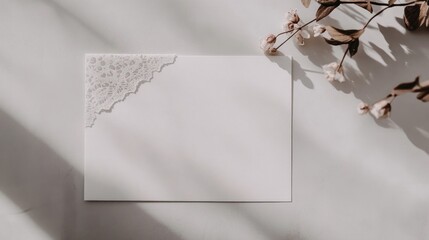 Minimalist wedding invitation mockup with lace detail and floral accents on a neutral backdrop