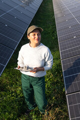 Female farmer with digital tablet on a modern farm using solar panels.