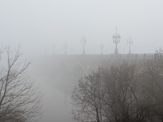 View of "Pont de Pierre" (bridge of stone) disappearing in the winter fog, Bordeaux, France
