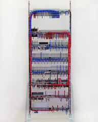The reverse side of the electrical switchboard. The connected wires are tied with plastic ties.