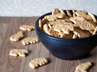 Animal shaped biscuits in a bowl. Sweet crackers on the table. Tea or coffee break 