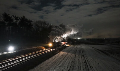 A train car is on fire next to snowy fields under a moonlit sky. Smoke billows into the air as...