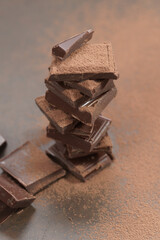 Broken dark chocolate and cocoa powder on a table