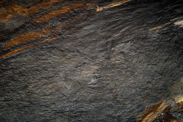 Close-Up of Dark and Textured Natural Rock Surface with Layered Details