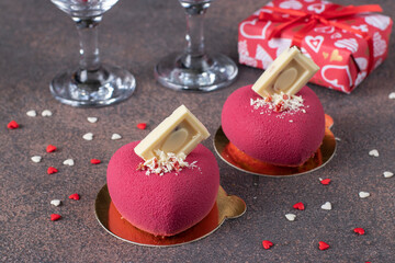 Bright mousse cakes Hearts with pink velour coating and white chocolate for Valentine's Day