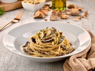 CREAMY TRUFFLE PASTA with mushroom served in dish isolated on wooden table side view of italian fast food
