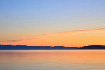 Fototapeta premium Sunset Gradient: A sky transitioning from deep orange to soft pink, with the horizon fading into a calm, dusky blue
