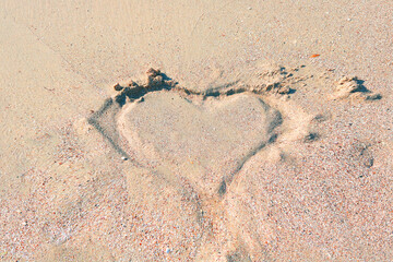 Abstract heart on sand on beach in evening before sunset