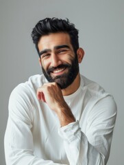 Saudi male model smiling with chin resting casually in indoor setting