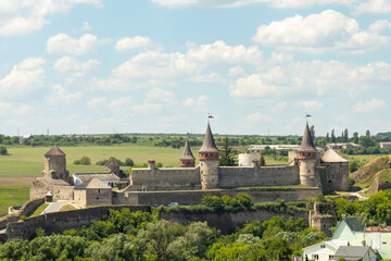Fototapeta premium Historic medieval castle with towers under a blue sky and green surroundings