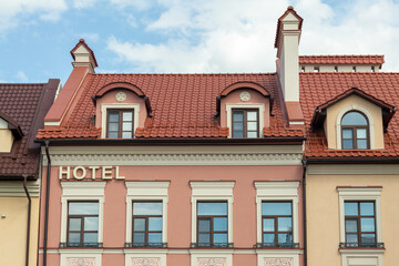 Charming hotel building facade with decorative windows and red tiled roof