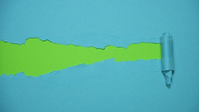 Blue paper background torn in half, revealing a green background that is also torn in half. Stop motion