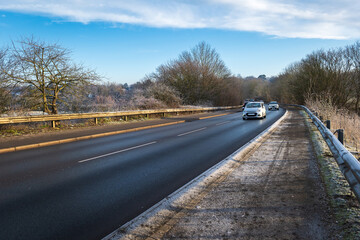 Frost snow covered british road and cars in england uk