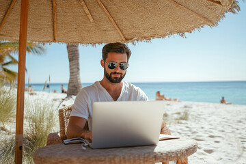 Remote Work on Sunny Beach: Man Using Laptop Under Straw Umbrella by Ocean
