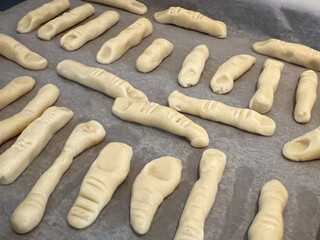 Homemade green witch finger cookies with almond nails, a perfect spooky snack for Halloween parties and horror-themed dessert menus. Ideal for food photography and seasonal promotions.