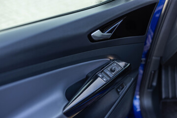 Window control buttons in modern luxury electric car. Car leather interior details of door handle...