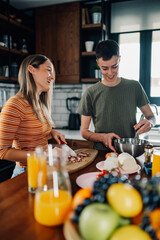 Lesbian couple preparing food and whisking eggs in modern kitchen