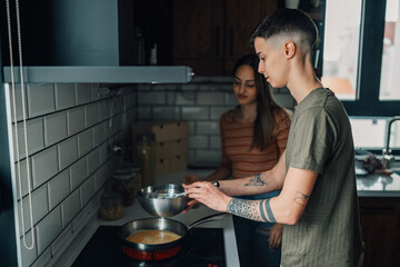 Lesbian couple preparing meal together in modern kitchen