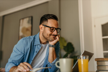 Freelancer using a laptop at home in a stylish and well-lit living room