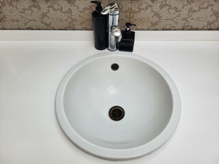 Round white washbasin in a public toilet