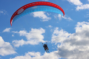Tandem Paraglider flying in a blue sky	
