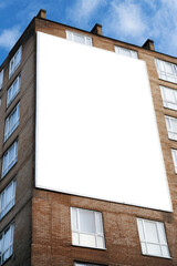 Big blank empty billboard on the side of block of flats. Apartment building, mockup with copy space, advertising billboard, commercial housing, real estate. Poster for property marketing, announcement