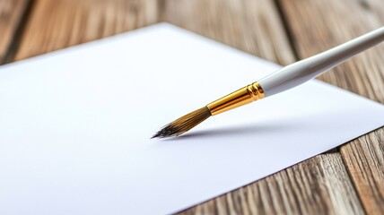 White paintbrush on blank paper wooden desk