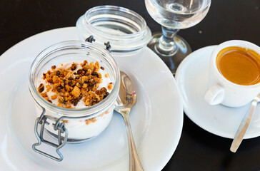 Tiramisu traditional italian dessert in glass jar, garnished with cookies