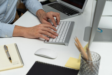 Cropped image of hands IT developer working online software information on pc and laptop with...