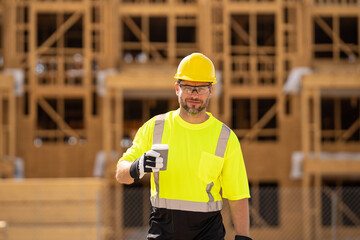 Construction worker having coffee break on construction site. A man builder in a helmet and goggles...