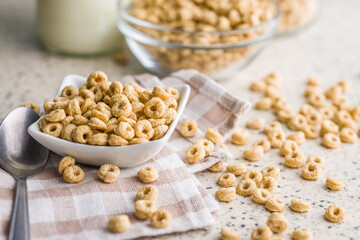 Sweet honey cereal rings in bowl on klitchen table.