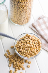Sweet honey cereal rings in bowl on white table.