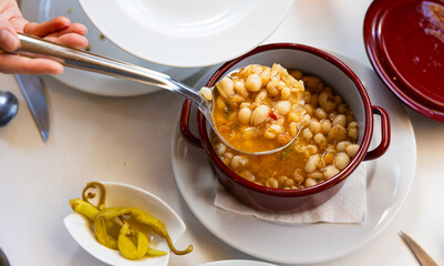 Pochas stewed with vegetables and ham bone in ladle. Aragonese cuisine