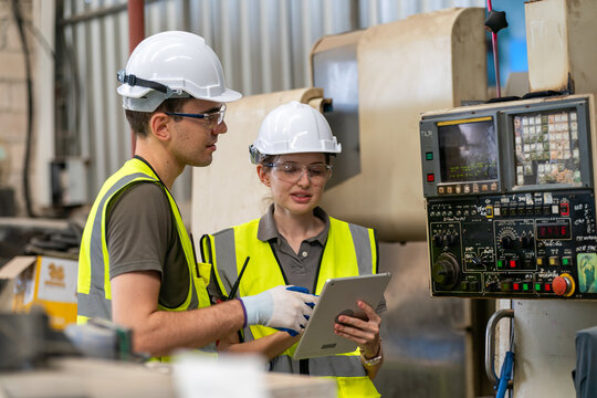 Colleagues review data while monitoring equipment in an industrial facility during working hours