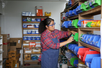 Organizing supplies in a storage room by a woman during work hours in a well-arranged warehouse