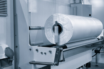 Automatic polyethylene plastic bag production machine with lighting effect. Close-up of the roller...