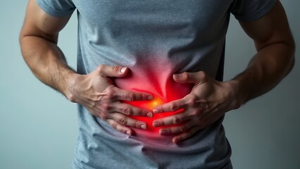 close-up photo of a faceless man holding his stomach with his hands in severe pain