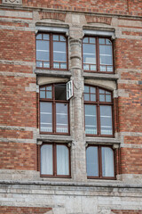 Small open window on a large window of a university building.