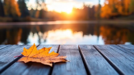 Romantic autumn sunset over misty lake with golden leaves on wooden bridge
