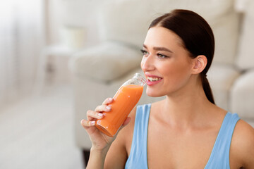 Fototapeta premium Healthy Lifestyle. Fit Girl Drinking Bottle Of Fruit Juice Losing Weight At Home. Free Space For Text