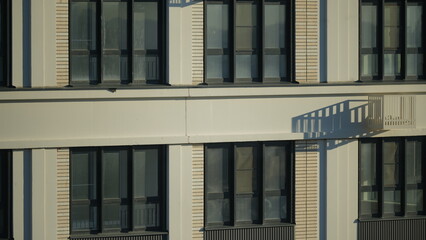 fragment of a multi-storey house with windows, balconies and decorative boxes for air conditioners