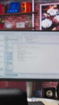 Vertical video Lines of code written on PC workstation screen on development tool application. Debugging software programming language displayed on computer monitor in living room office