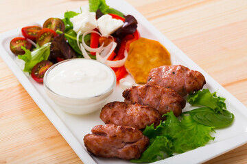 Cevapcici with green salad and young cheese - traditional Bulgarian meat dish