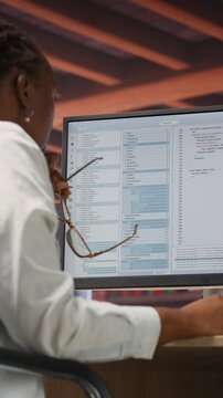 Vertical video Irked software developer frustrated while coding, struggling to implement algorithms. Unhappy IT expert annoyed while working with code editor, unable to optimize performance, camera B