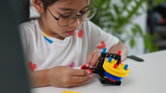 STEM education concept. Asian home school girls self-study online lessons and are excited to make STEM toys. mathematics engineering science technology computer code in robotics for kids' concepts.