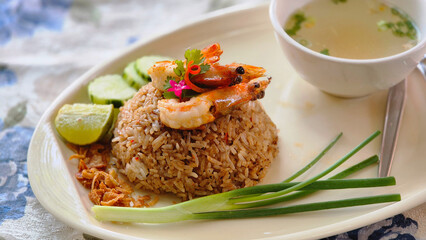 Thai-style fried rice with shrimp served with soup, lime, cucumber, and spring onions.